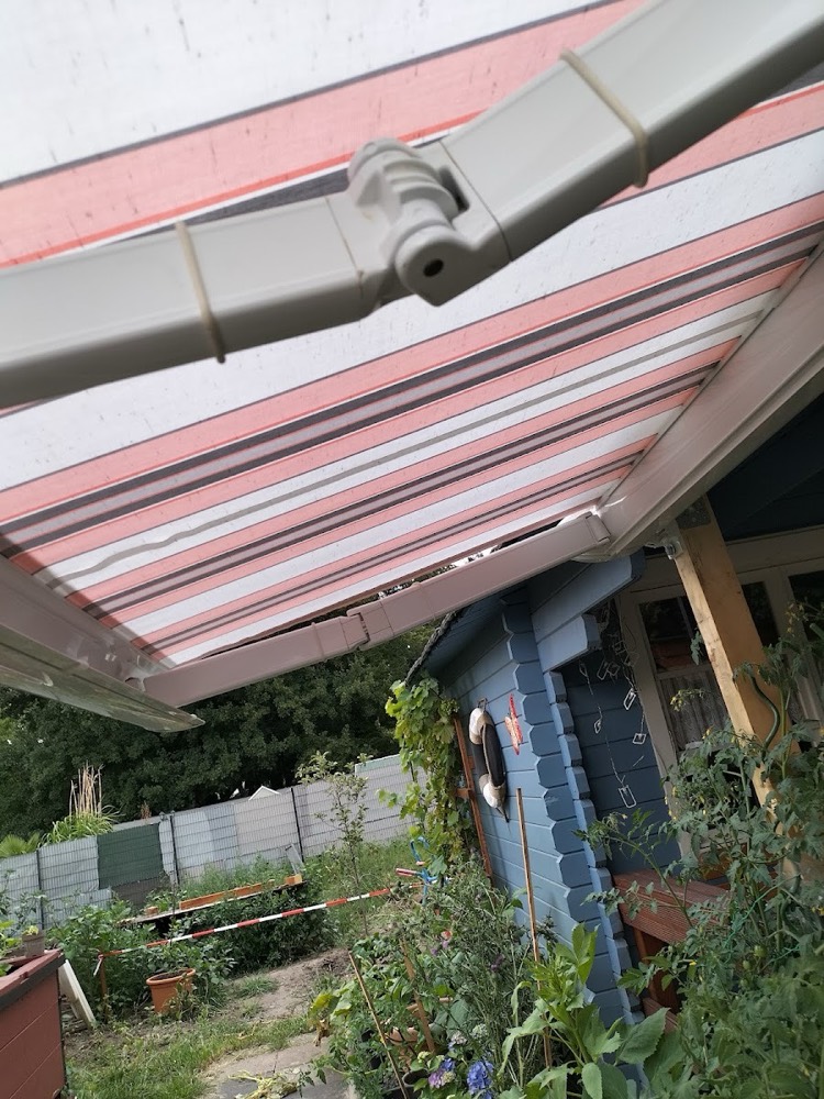 Markise in Rosa-Grau und Weiß gestreift, von unten fotografiert